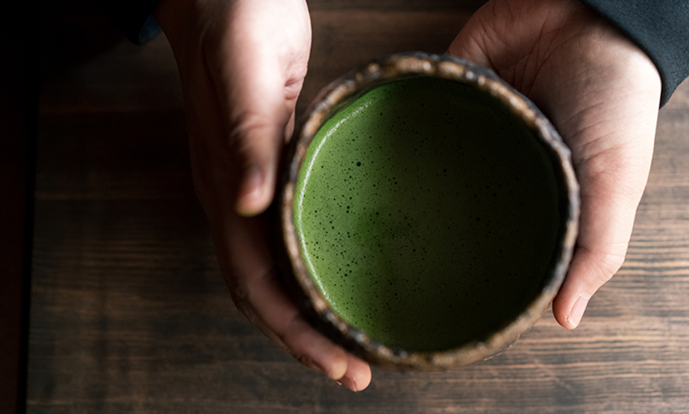 抹茶が入った器を手で持つ